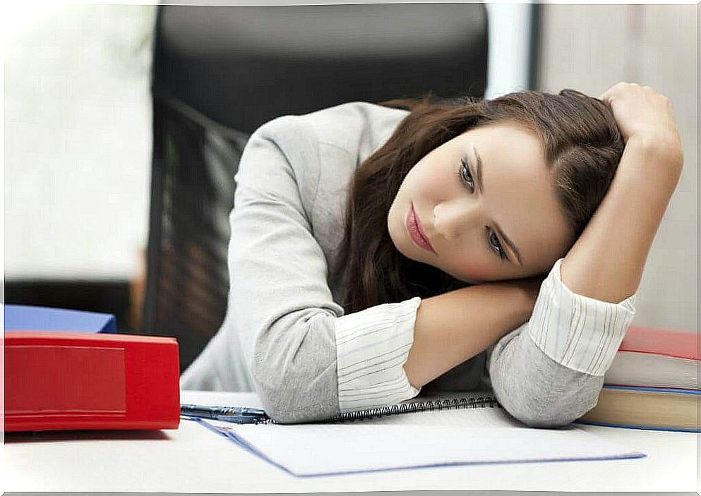 Woman hanging over the table at work - has hypothyroidism