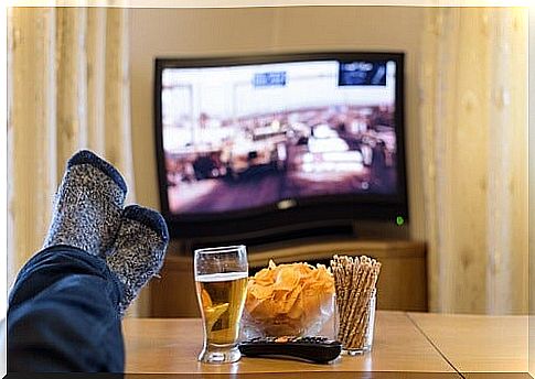 Man watching TV with beer and chips