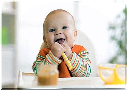 A happy baby eats commercial baby food