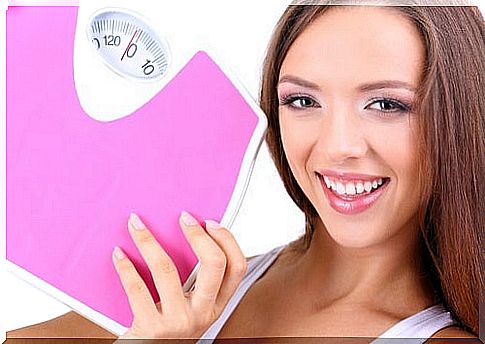 Young woman standing with a bathroom scale