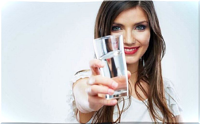 Woman with a glass of water - juice for the intestines