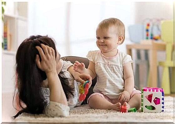 Mother playing with baby on floor