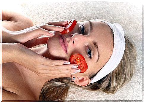 Young woman with tomatoes on her cheeks