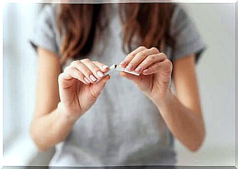 Woman cracks cigarette as symbol of smoking cessation