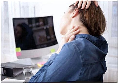 Person massaging neck at desk