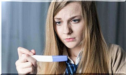 Woman with pregnancy test is worried about different types of abortion