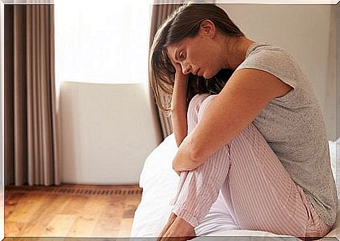 Woman sitting in bed depressed